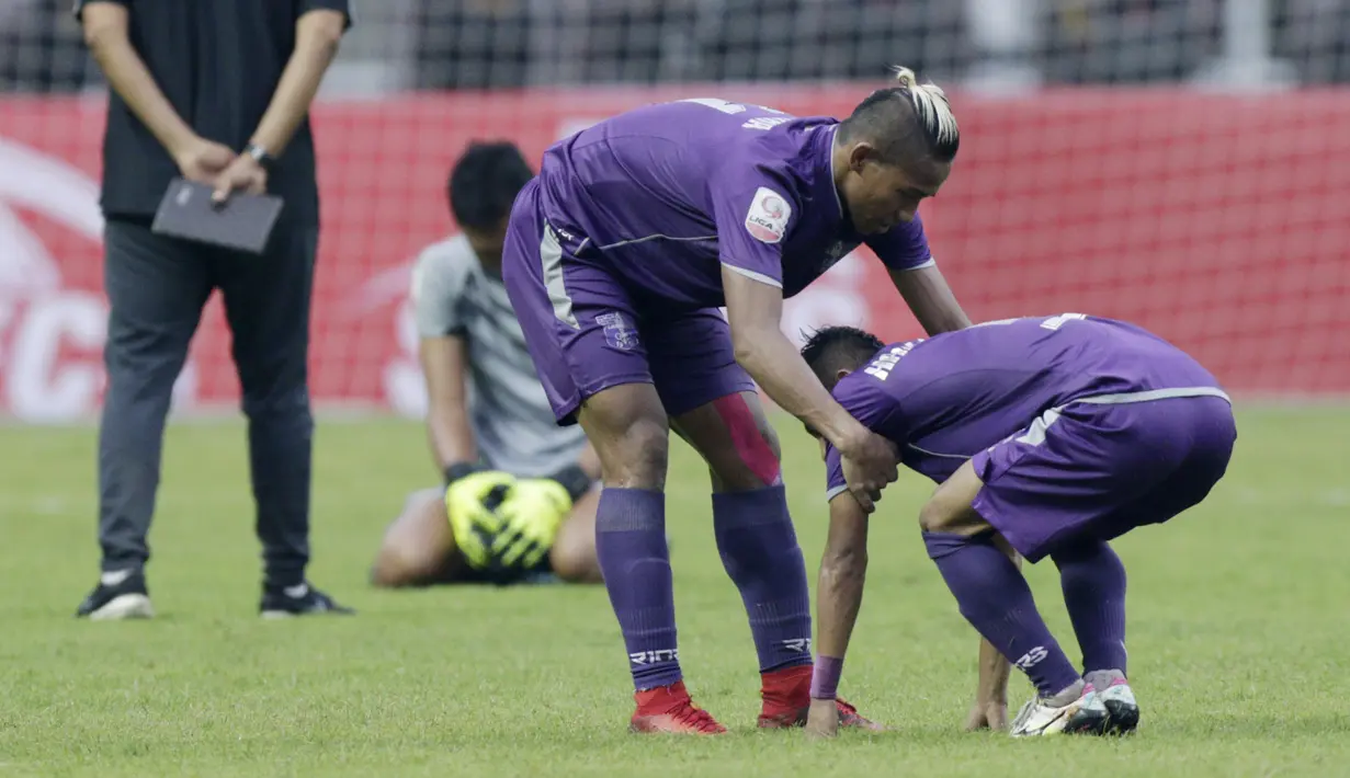 Gelandang Persita Tangerang, Muhammad Toha, mengangkat rekannya usai ditaklukkan Kalteng Putra pada laga Liga 2 di Stadion Pakansari, Jawa Barat, Selasa (4/12). Kalteng menang 2-0 atas Persita. (Bola.com/M. Iqbal Ichsan)