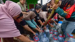 Warga antre mendapatkan air bersih saat pemberian bantuan air bersih yang dilakukan Relawan Gerak Bareng di Desa Cidokom, Bogor, Jawa Barat, Kamis, 30 Juli 2026. (KLY/Arie Basuki)