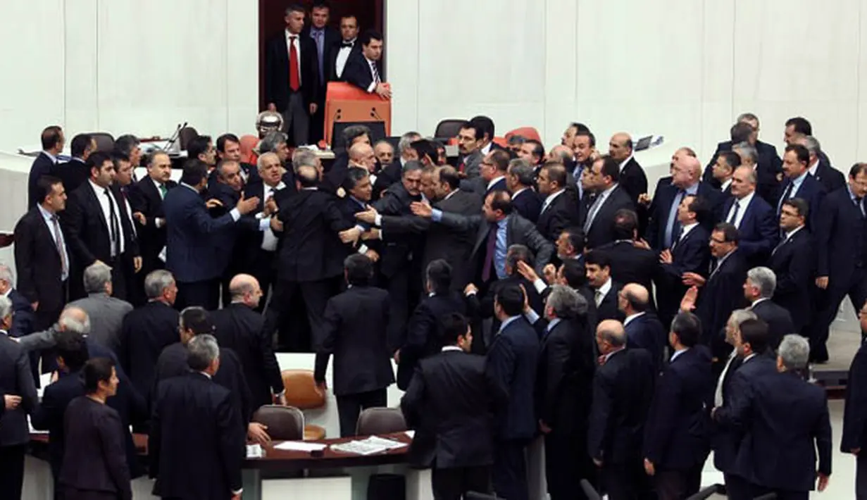 Keributan antara anggota parlemen partai oposisi (CHP) dan partai berkuasa AK saat pembahasan undang-undang untuk meningkatkan kekuatan polisi di Ankara, Turki, Kamis (19/2). (AFP PHOTO/ADEM ALTAN)