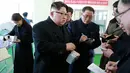 Gambar yang dirilis pada Kamis (25/1), menunjukkan Pemimpin Korea Utara, Kim Jong-un berbincang dengan sejumlah pejabat saat mengunjungi pabrik farmasi di Pyongyang. Dalam kunjungannya tesebut, Kim Jong-un ditemani istrinya, Ri Sol-Ju (KCNA VIA KNS/AFP)