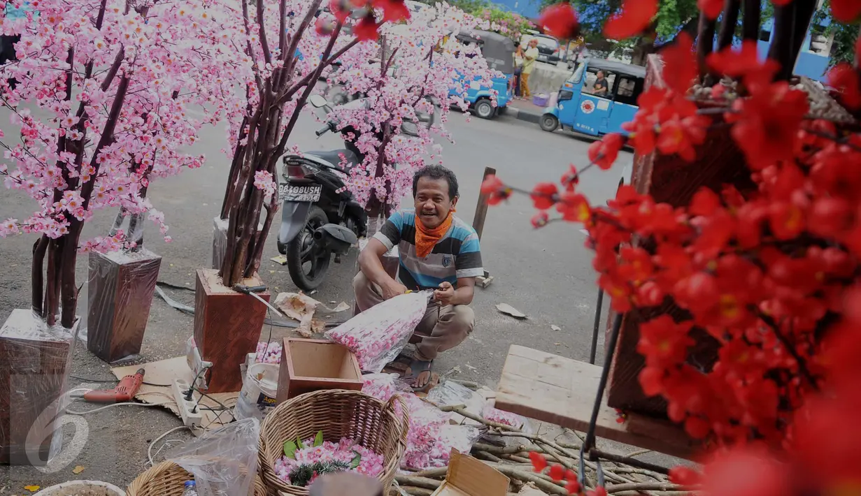 Pengrajin Pohon Hias Imlek menyelesaikan pekerjaannya di kawasan Glodok, Jakarta, Kamis (21/1/2016). Pembeli dapat memesan sesuai keinginan dengan kisaran harga 50.000 - 3.500.000 rupiah. (Liputan6.com/Gempur M Surya)