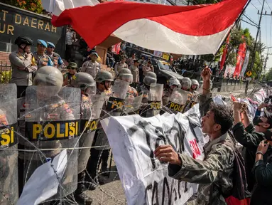 Pengunjuk rasa yang terdiri dari mahasiswa, buruh dan sejumlah elemen masyarakat meneriakkan slogan-slogan dalam aksi unjuk rasa di depan gedung Dewan Perwakilan Rakyat Daerah Provinsi Jawa Timur di Surabaya pada tanggal 23 Agustus 2024. (JUNI KRISWANTO/AFP)