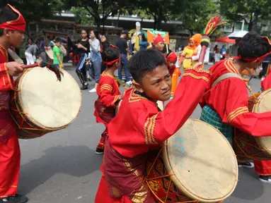Seniman cilik memainkan alat musik tambur khas Minangkabau saat car free day (CFD) di Jakarta, Minggu (13/1). Pertunjukan tersebut untuk mengenalkan alat musik tradisional Nusantara kepada masyarakat. (Liputan6.com/Angga Yuniar)