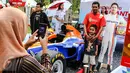 Pengunjung berfoto bersama di replika mobil Formula 1 yang ditunggangi pembalap Indonesia, Rio Haryanto pada acara Nonton Bareng F1 GP Australia 2016 Pertamina di Mall Bintaro Xchange, Tangerang Selatan, Minggu (20/3). (Liputan6.com/Fery Pradolo)