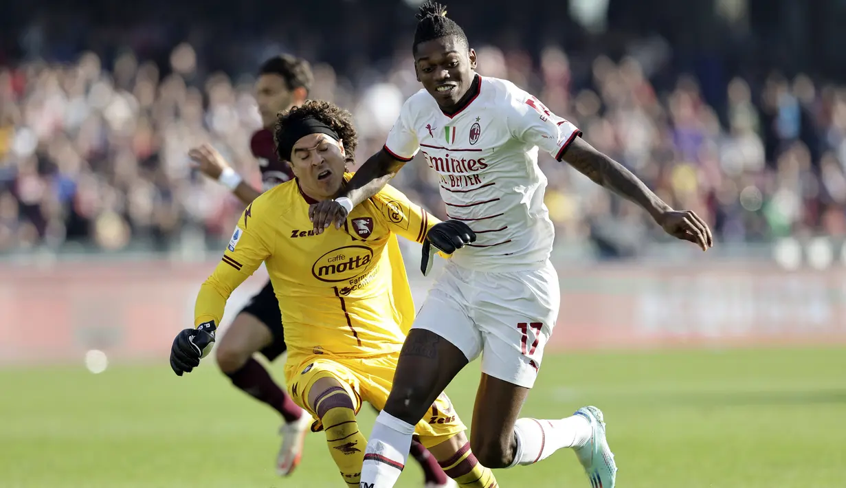 Penyerang AC Milan, Rafael Leao berusaha melewati kiper Salernitana, Guillermo Ochoa untuk mencetak gol selama pertandingan lanjutan Liga Serie A Italia di stadion Arechi di Salerno, Italia, Rabu (4/1/2023). AC Milan menang tipis atas Salernitana  dengan skor 2-1. (Alessandro Garofalo/LaPresse via AP)