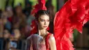 Yuki Kato tampil merah merona bak burung phoenix, mengenakan gaun dan sayap merah, serta makeup art deco yang seru. [Instagram/nasionp]