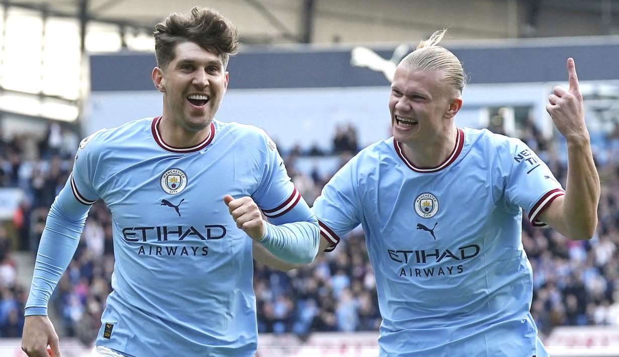 Pemain Manchester City John Stones dan Erling Haaland merayakan gol ke gawang Leicester City pada pekan ke-31 Premier League 2022/2023, Sabtu (15/4/2023). Sejauh ini, torehan gol terbanyak dalam satu musim Premier League adalah 34. Rekor tersebut diukir oleh Andy Cole musim 1993/1994 dan Alan Shearer musim 1994/1995. Haaland hanya butuh tiga gol lagi untuk melewati keduanya. (Nick Potts/PA via AP)