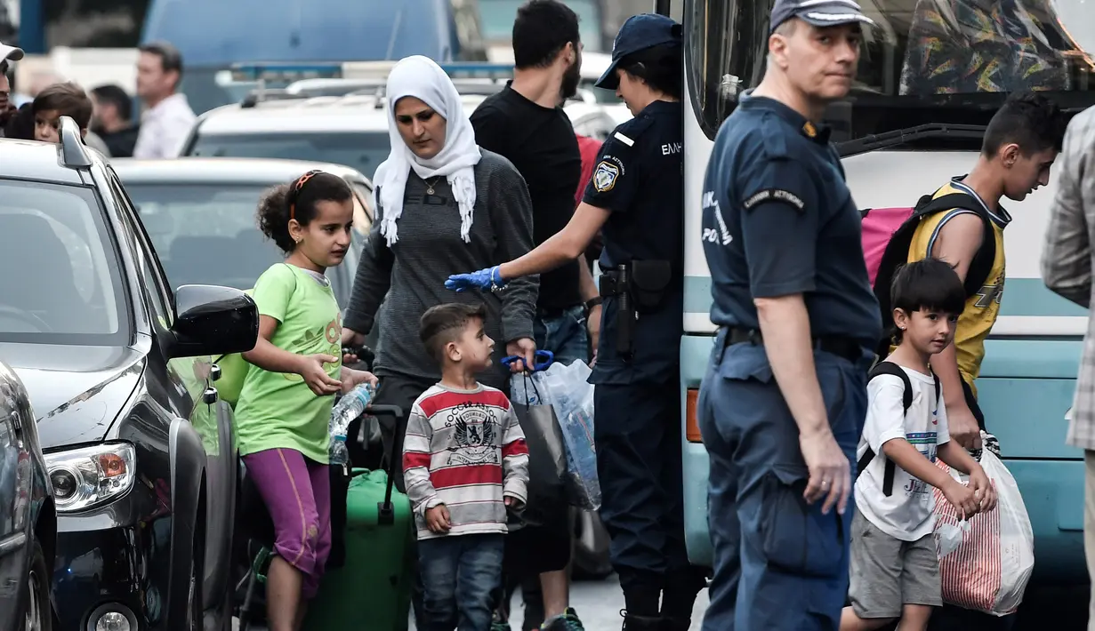Para migran bersiap naik bus selama operasi polisi di pusat Athena, Yunani (19/9/2019). Polisi di Athena pada 19 September 2019 memindahkan lebih dari 200 migran, termasuk lusinan anak-anak, dari dua tempat di pusat kota sebagai bagian dari pembersihan. (AFP Photo/Louisa Gouliamaki)