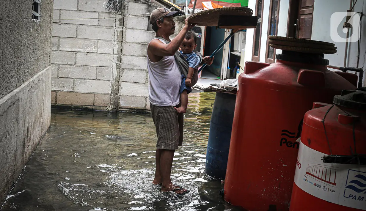 Warga beraktivitas saat banjir rob di Muara Angke, Jakarta, Jumat (25/11/2022). Badan Penanggulangan Bencana Daerah (BPBD) DKI Jakarta mengimbau agar warga di pesisir Jakarta mengantisipasi banjir pesisir atau rob selama 22-28 November 2022. (Liputan6.com/Faizal Fanani)