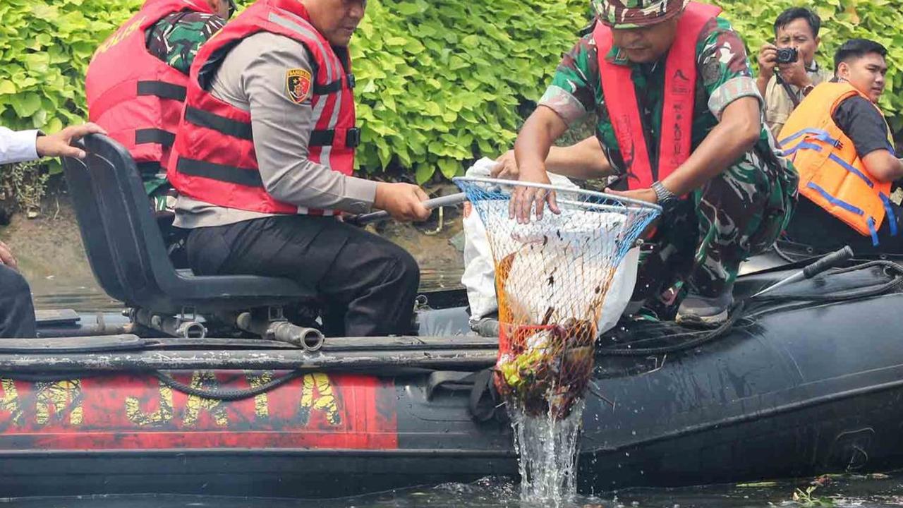 Kapolda Metro Jaya Irjen Karyoto dan Pangdam Jaya Mayjen Mohamad Hasan memperlihatkan kekompakan membersihkan sampah di aliran Kali Ciliwung, dekat RPTRA Kalijodo, Jakarta Utara, pada Selasa (15/8/2023).