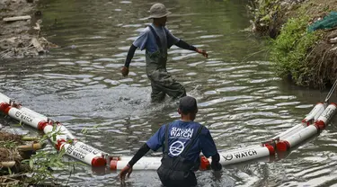 Anggota komunitas Sungai Watch memasang penghalang sampah baru di sebuah sungai di distrik Kerobokan, Bali, pada 14 Desember 2023. (David GANNON/AFP)