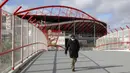 Seorang pria yang mengenakan masker berjalan di luar Stadion SL Benfica, Kota Lisbon, Portugal, 29 November 2021. Otoritas kesehatan Portugal mengidentifikasi 13 kasus COVID-19 varian Omicron. (AP Photo/Ana Brigida)