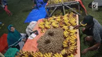 Pedagang menjual pisang dan kacang di pasar malam pada tradisi Malam Qunut di Desa Payunga, Kec. Batudaa, Kab. Gorontalo, Senin (20/5/2019). Tradisi Malam Qunut di Gorontalo dilakukan pada setiap pertengahan bulan Ramadan dengan beramai-ramai memakan pisang dan kacang. (Liputan6.com/Arfandi Ibrahim)