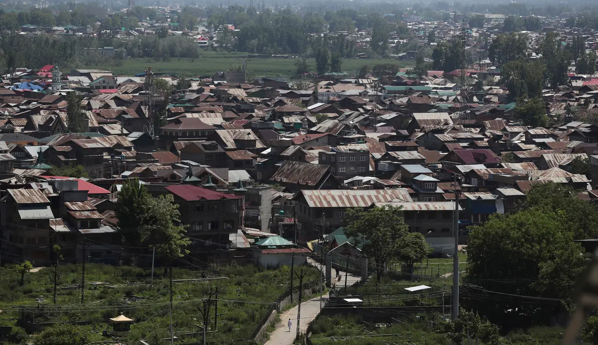 Seorang pria berjalan di jalan yang sepi selama penguncian di Srinagar, Kashmir yang dikuasai India (8/5/2020). Para ulama dan otoritas agama di bagian Kashmir India telah mendesak orang-orang untuk beribadah di dalam rumah mereka untuk mencegah penyebaran Covid-19 . (AP Photo/Mukhtar Khan)