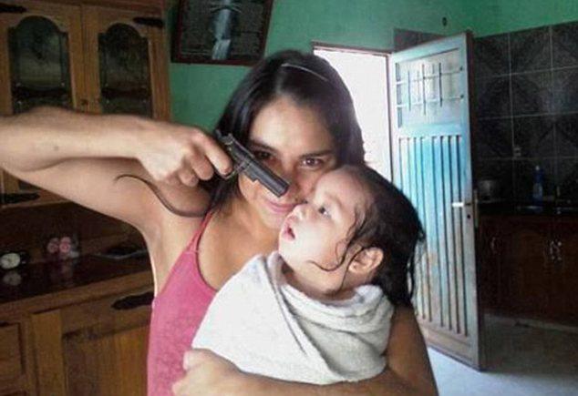 Foto wanita menodongkan pistol ke arah bayi(c) dailymail.co.uk
