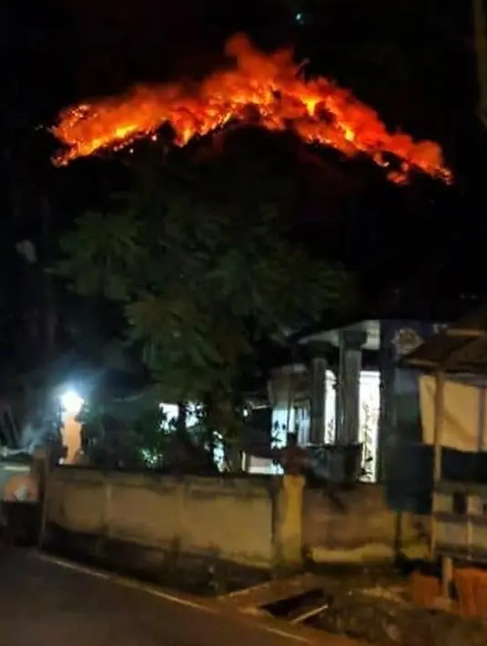 Lava pijar Gunung Agung menyembur dari puncak gunung di Karangasem, Bali, Senin (2/7). Gunung Agung melontarkan lava pijar sejauh 2 kilometer dan membuat hutan di sekitar Gunung Agung terbakar. (Handout / Badan Nasional Penanggulangan Bencana / AFP)