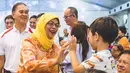 Halimah Yacob saat tos kepada seorang anak pada Festival Hantu Lapar yang dihadiri 4000 tamu undangan di Kuil Sheng Hong, Singapura (08/9). (instagram.com/halimahyacob)