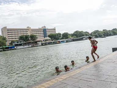 Sejumlah anak berenang di Danau Sunter, Jakarta, Selasa (2/2/2021). Minimnya lahan bermain anak membuat mereka memanfaatkan tempat yang tidak semestinya untuk bermain karena adanya risiko hanyut dan tenggelam bila tidak mampu untuk berenang. (Liputan6.com/Faizal Fanani)