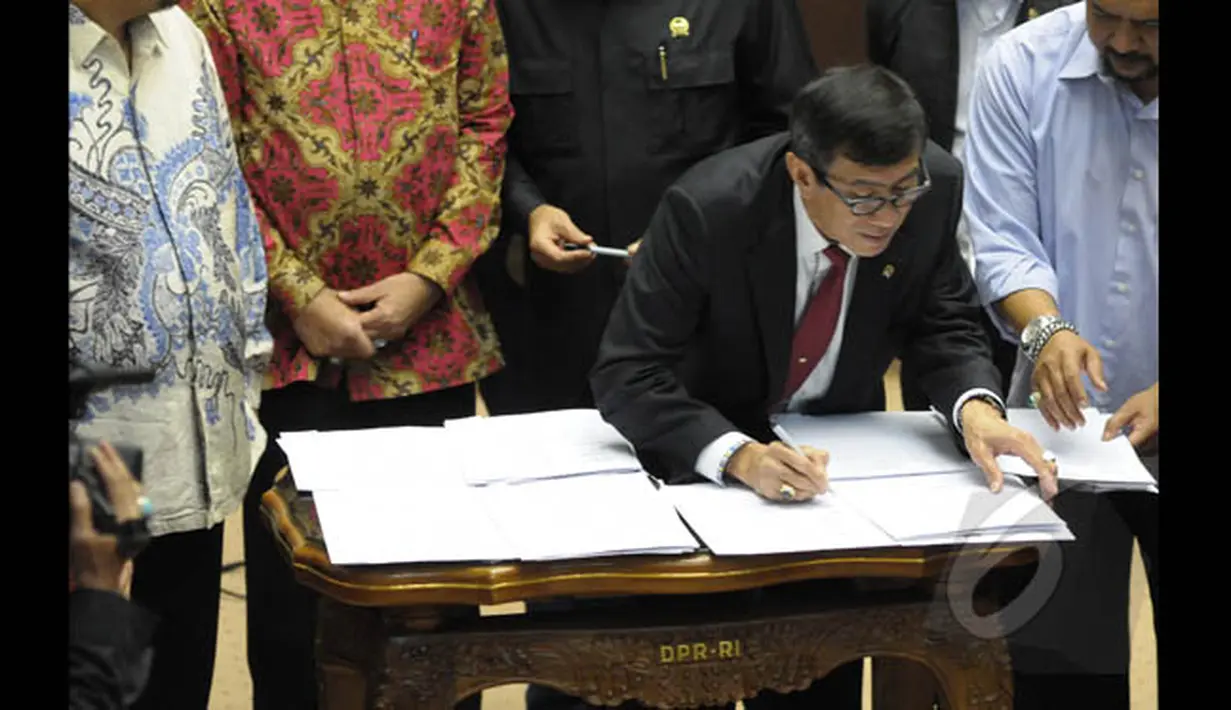 Menkumham Yasona Laoly menandatangi Perppu Pilkada dalam rapat kerja bersama Komisi II DPR di Gedung Nusantara, Kompleks Parlemen Senayan, Jakarta, Senin (19/1/2015). (Liputan6.com/Andrian M Tunay)