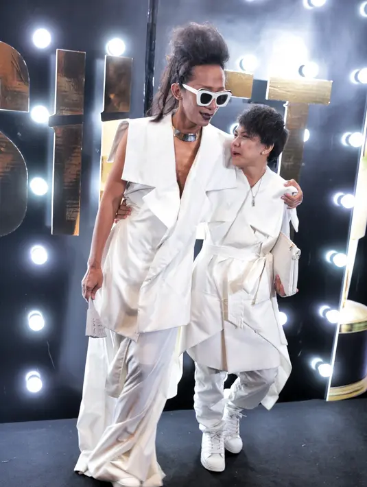 Pemeran dalam film 'The Wedding & Bebek Betutu' mengenakan kalung gold sambil menenteng kipas terbuat dari kayu. Lelaki kelahiran Jakarta, 35 tahun silam itu juga menyasak rambut dan memoles bibirnya dengan lipstick warna gelap. (Adrian Putra/Bintang.com)