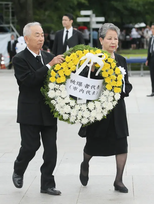 Perwakilan korban bom atom meletakkan karangan bunga selama upacara peringatan di Hiroshima Peace Memorial Park, Hiroshima, Selasa (5/8/2019). Pemerintah Jepang menggelar peringatan jatuhnya bom atom di Kota Hiroshoma 74 tahun lalu yang menandai berakhirnya Perang Dunia (PD) II. (JIJI PRESS / AFP)