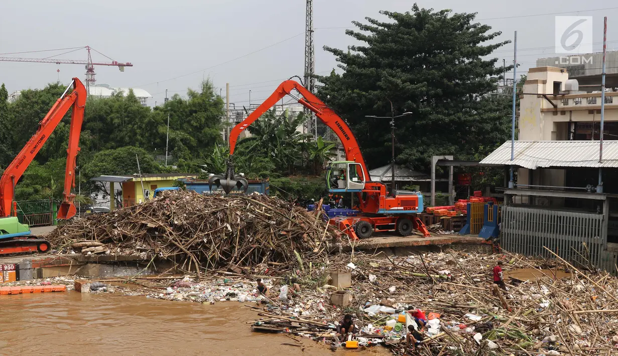 Alat berat mengangkat sampah yang menumpuk di Pintu Air Manggarai, Jakarta, Jumat (26/4). Sampah yang didominasi potongan bambu dan botol plastik kembali memenuhi Pintu Air Manggarai akibat curah hujan yang tinggi di kawasan Bogor dan sekitarnya, Kamis (25/4). (Liputan6.com/Helmi Fithriansyah)