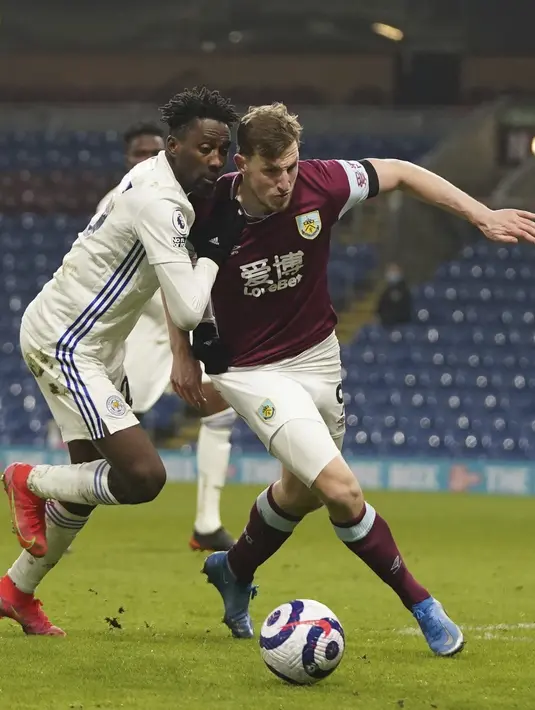 Gelandang Leicester City, Wilfred Ndidi berusaha merebut bola dari pemain Burnley, Chris Wood pada pertandingan Liga Inggris di stadion Turf Moor di Burnley, Inggris, Kamis (4/3/2021). Leicester City bermain imbang atas Burnley 1-1. (Jon Super/Pool via AP)