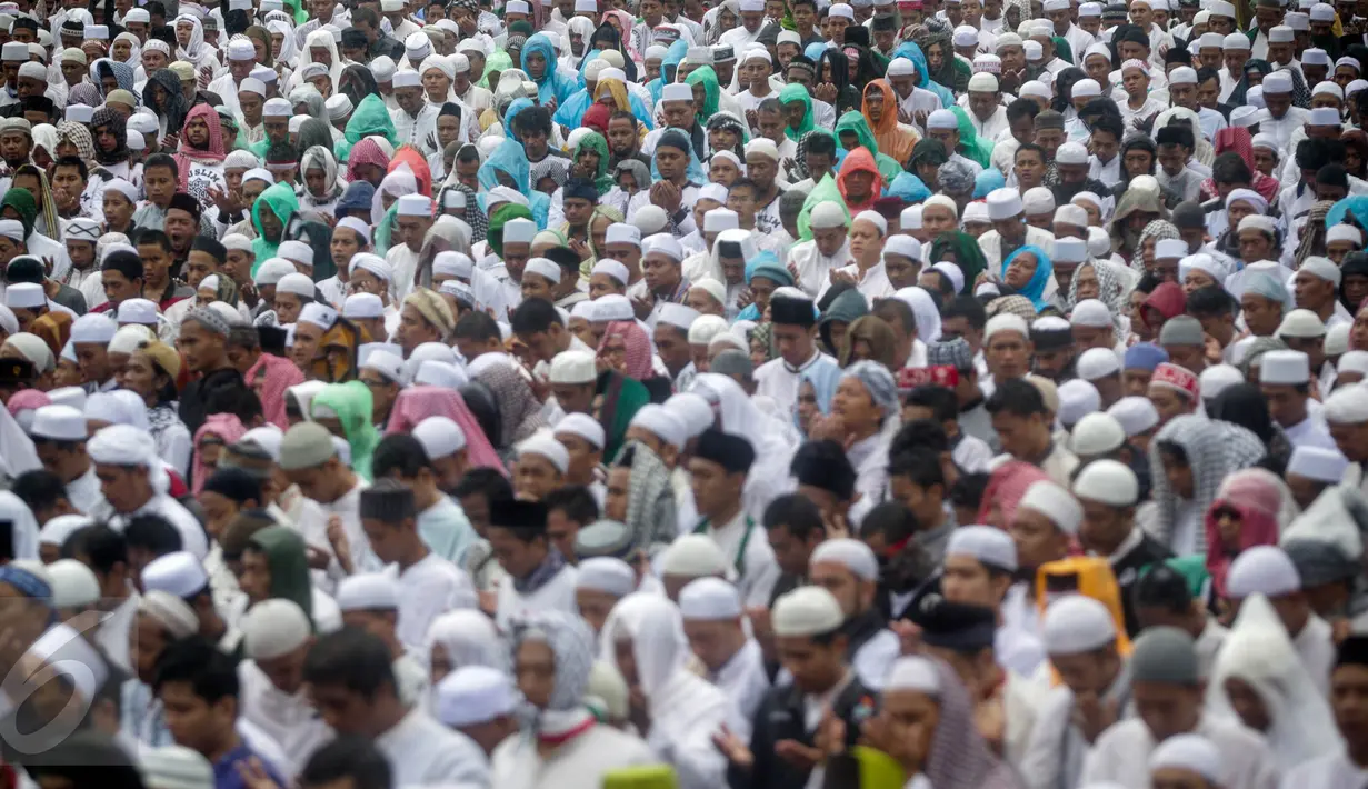 Ribuan peserta aksi damai 2 Desember berdoa saat melaksanakan salat Jumat di Monas, Jakarta, Jumat (2/12). Meski hujan mengguyur, massa tetap bertahan di saf masing-masing dan melangsungkan salat Jumat bersama-sama. (Liputan6.com/Faizal Fanani)