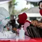 Petugas kesehatan mendata pegawai KPU dan Wartawan saat mengikuti swab test dan tes diagnostik cepat (rapid test) COVID-19 secara massal di Gedung KPU, Jakarta, Selasa (4/8/2020). (merdeka.com/Faizal Fanani)