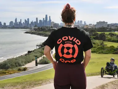 Seorang wanita melihat ke cakrawala Melbourne saat dia istirahat dari olahraga (11/8/2020). Negara bagian Victoria melaporkan 19 kematian akibat virus corona pada 11 Agustus, menjadikannya hari yang sama mematikan bagi pandemi di negara itu meskipun jumlah kasus baru turun. (AFP/William West)