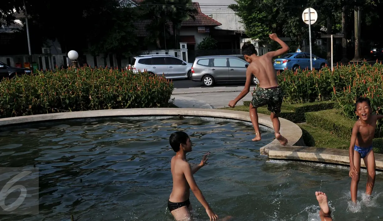 Anak-anak  berenang di kolam air mancur di kawasan Jalan Diponogoro, Jakarta, Jumat (31/7/2015). Minimnya lahan bermain di Ibukota, membuat mereka memanfaatkan kolam air mancur sebagai tempat berenang. (Liputan6/Johan Tallo)