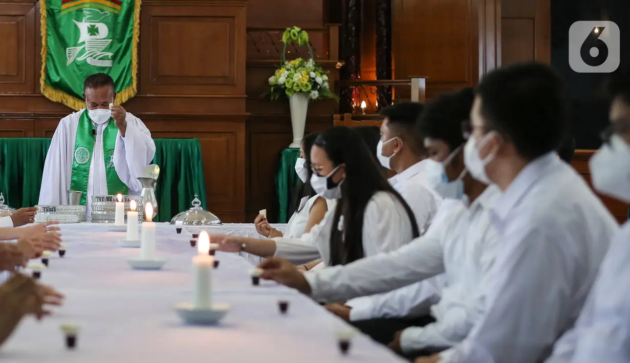 Jemaat melakukan Ibadah Perjamuan Kudus tatap muka pertama di Gereja Protestan Indonesia Bagian Barat (GPIB) Effatha, Jakarta, Minggu (3/10/2021). Jemaat yang beribadah diwajibkan sudah vaksin, dalam kondisi sehat dan mengurangi kapasitas ruangan. (Liputan6.com/Johan Tallo)