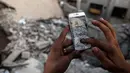 Seorang gamer Suriah menemukan Pokemon di antara reruntuhan di daerah konflik Suriah, Damaskus (23/7). (AFP PHOTO / Sameer Al-Doumy)