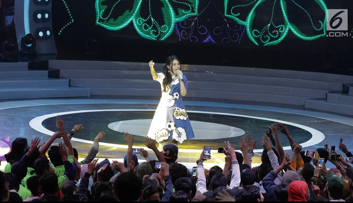Penonton mengambil gambar pedangdut Via Vallen ketika bernyanyi dalam launching  Kompetisi Gojek Traveloka Liga 1 2018 di Studio 5 Indosiar, Jakarta, Senin (19/3). Via menyanyikan tiga lagu. (Liputan6.com/Faizal Fanani)