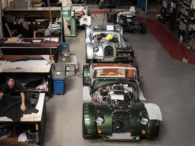 Pekerja mencetak kulit yang akan dibuat sebagai jok mobil klasik sport di pabrik mobil Morgan Motor Company di Malvern, Birmingham, Inggris (13/8/2019). Morgan Motor Company didirikan pada tahun 1909 oleh HFS Morga. (AFP Photo/Oli Scarff)