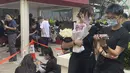 Di luar rumah duka di bagian timur pulau Hong Kong, hampir seribu penggemar, banyak yang berpakaian hitam, mengantri di tengah teriknya cuaca untuk memasuki aula pemakaman yang dibuka untuk umum setelah kebaktian pribadi. (AP Photo/Annie Cheung)