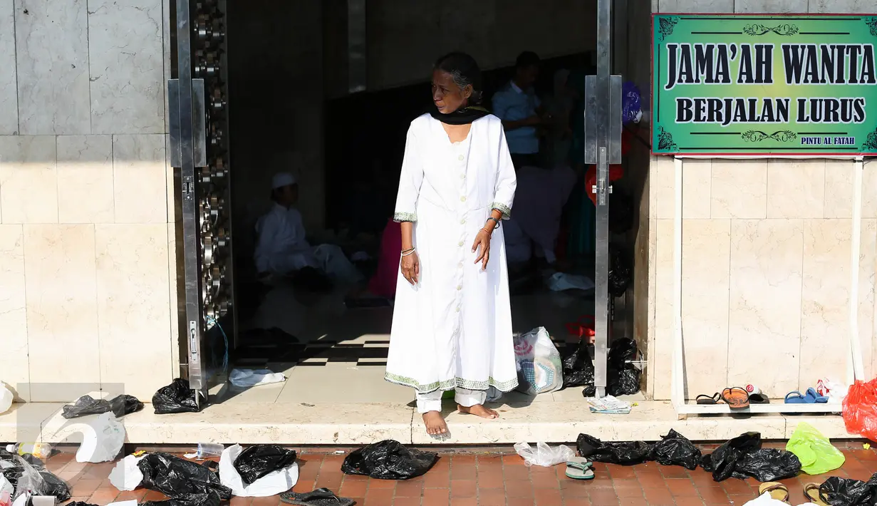 Seorang jemaah berdiri di dekat sampah plastik yang berserakan di area Masjid Istiqlal, Jakarta, Rabu (6/7). Sampah-sampah plastik bekas bungkus sepatu jemaah saat salat Id dibuang begitu saja di halaman masjid. (Liputan6.com/Faizal Fanani)