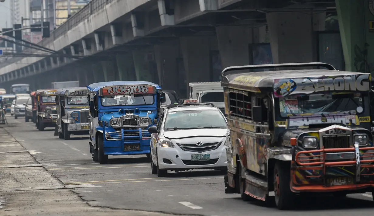 Penumpang jeepney bepergian di sepanjang jalan di Manila, sehari sebelum pihak berwenang mencabut perintah tinggal di rumah pada Selasa (7/9/2021). Filipina akan mencabut lockdown di ibu kota Manila pada Rabu (8/9), saat kasus corona harian naik dua kali lipat. (Ted ALJIBE/AFP)