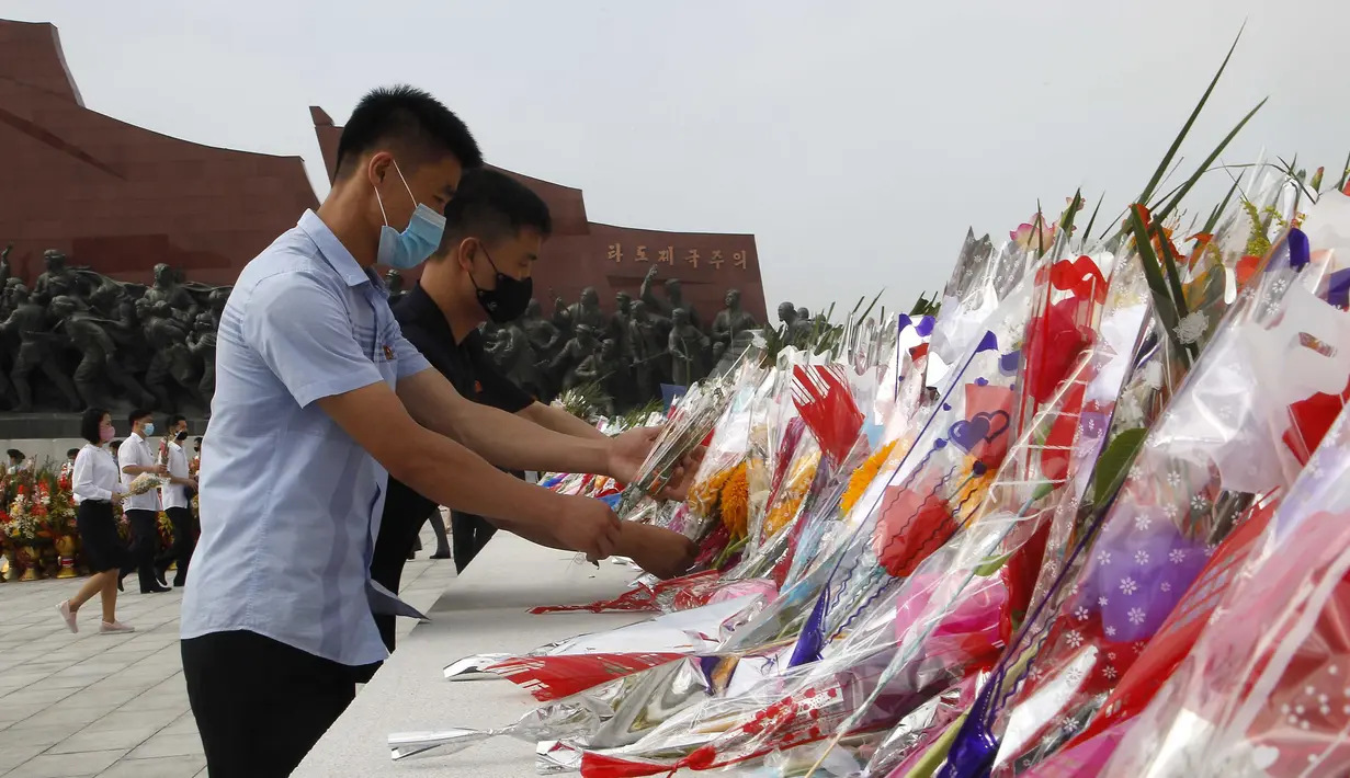 Sejumlah warga menaruh bunga saat mengunjungi Mansu Hill untuk memberi penghormatan terhadap patung-patung perunggu dari Kim Il-sung dan Kim Jong-il pada peringatan 26 tahun kematian Kim Il-sung di Pyongyang, Korea Utara, Rabu (8/7/2020). (AP Photo/Jon Chol Jin)