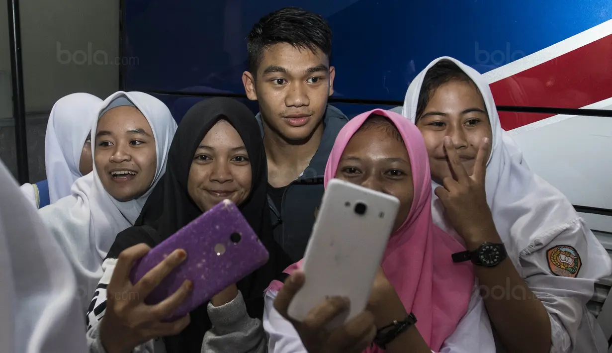 Bek Timnas Indonesia U-19, Samuel Christianson, selfie bersama fans usai latihan di Stadion Wibawa Mukti, Bekasi, Senin (16/10//2017). Kehadiran fans dengan senang hati disambut pemain Timnas U-19. (Bola.com/Vitalis Yogi Trisna)