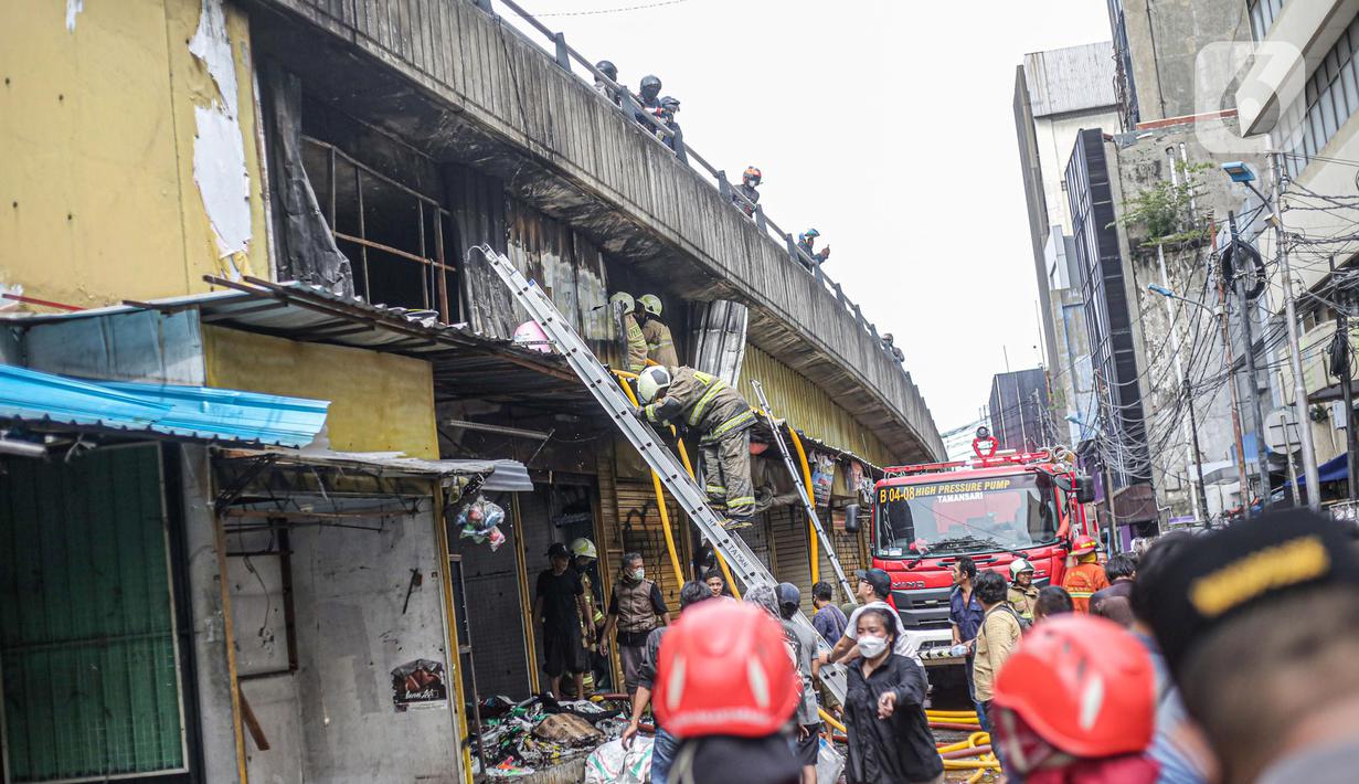 Petugas pemadam kebakaran saat melakukan proses pendinginan dari kebakaran di Pasar Pagi Asemka, Jakarta, Jumat (18/11/2022). Menurut Kepala Sektor Tambora Sudin Gulkarmat Jakarta Barat, Joko Susilo, api menghanguskan sekitar 20 lapak pedagang. (Liputan6.com/Faizal Fanani)