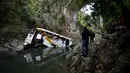 Awak media mengambil gambar sebuah bus berisi anggota tim sepak bola yang terjun ke jurang dari sebuah jembatan di Negara Bagian Veracruz, selatan Meksiko, Minggu (10/1). Sedikitnya 20 orang penumpang tewas dalam kecelakaan ini. (REUTERS/Yahir Ceballos)