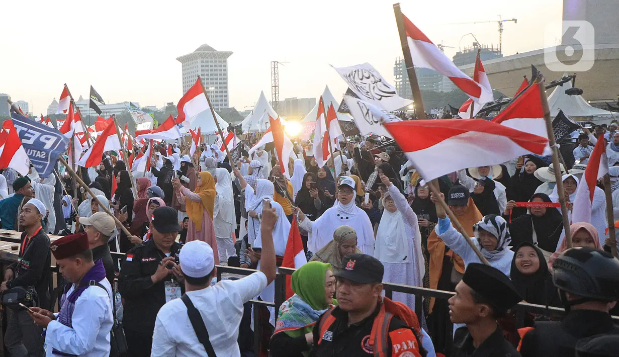 Massa mengibarkan bendera Merah Putih saat mengikuti acara Munajat dan Maulid Akbar 2019 #ReuniMujahid212 di kawasan Monas, Jakarta, Senin (2/12/2019). Dalam acara tersebut, massa turut mendoakan agar Imam Besar FPI Rizieq Shihab segera dipulangkan. (Liputan6.com/Herman Zakharia)