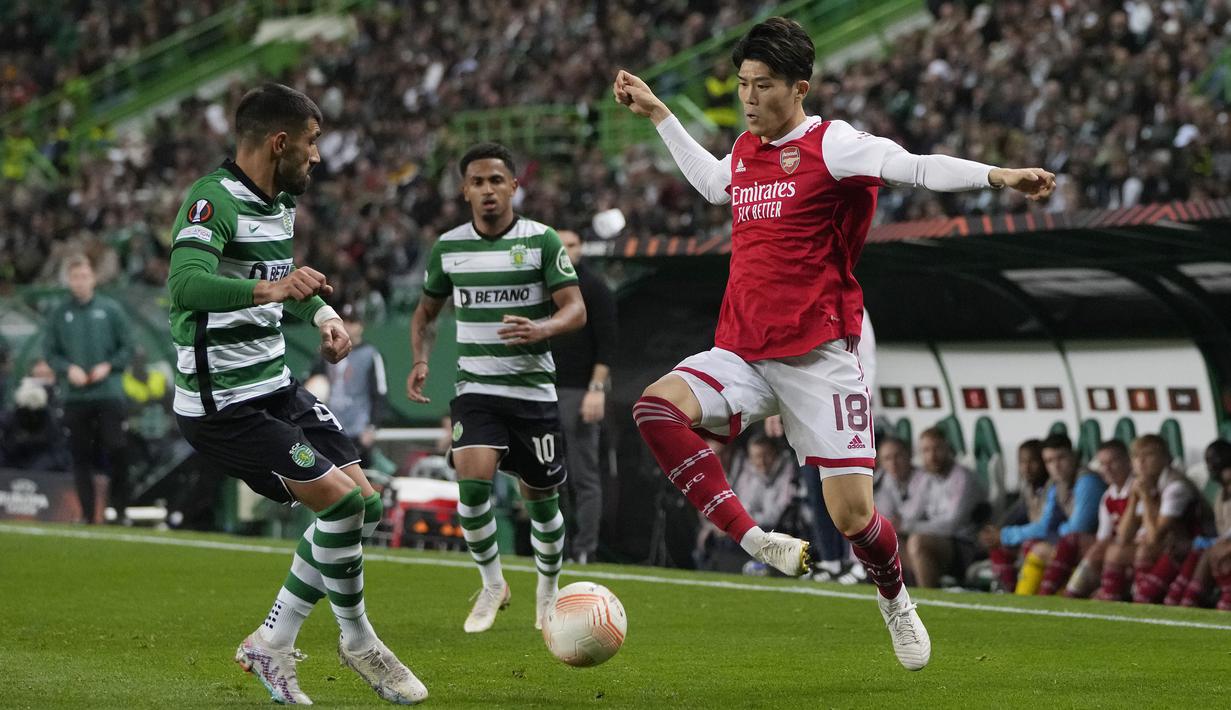Pemain Arsenal, Takehiro Tomiyasu (kanan) berusaha melewati pemain Sporting CP, Ricardo Esgaio pada laga leg pertama Liga Europa 2022/2023 di Jose Alvalade Stadium, Lisbon, Jumat (10/03/2023) dini hari WIB. Laga berakhir dengan skor imbang 2-2. (AP Photo/Armando Franca)