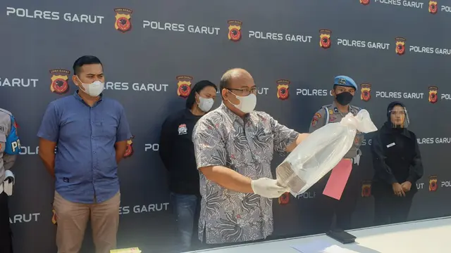 Kasat Reskrim Polres Garut AKP Dede Sopandi menunjukan sejumlah barang bukti yang digunakan pelaku I, dalam peristiwan berdarah sabetan cangkul yang menewaskan tetangganya di Limbangan Garut. (Liputan6.com/Jayadi Supriadin)