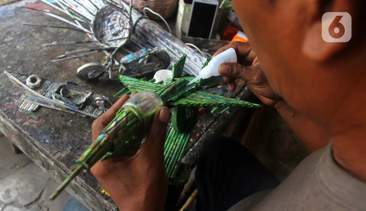 Perajin menyelesaikan miniatur pesawat di bengkel Workshop kawasan Kemandoran 8 Jakarta Selatan, Senin (10/2/2020). Berbagai kerajinan tangan berbahan dasar koran bekas dijual dengan harga Rp. 50.000 ribu hingga Rp. 150 ribu tergantung tingkat kesulitan dalam pengerjaan. (merdeka.com/Arie Basuki)