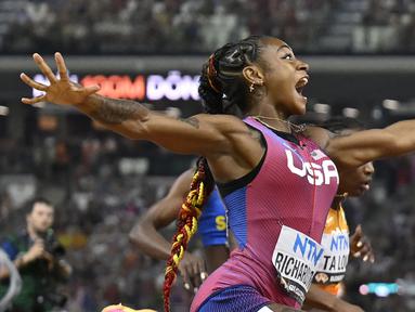 Pelari Amerika Serikat, Sha’Carri Richardson melakukan selebrasi saat melewati garis finis pada final 100 meter putri Kejuaraan Dunia Atletik 2023 di National Athletics Centre, Budapest, Hungaria, pada 22 Augustus 2023. (AP Photo/Denes Erdos)