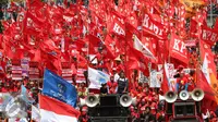 Sejumlah buruh membawa bendera berwarna merah saat aksi May Day 2016 di Jakarta, Minggu (1/5). Kaum buruh mengajukan tuntutan menolak upah murah serta pencabutan PP No. 78 Tahun 2015. (Liputan6.com/Angga Yuniar)