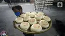 Pekerja membawa kue bulan di Industri Rumahan Kue Bulan Putri Lauw, Pondok Sentul, Ciater, Tangerang Selatan, Selasa (10/11/2020). Pada masa pandemi sekarang, produksi kue tradisional khas Tionghoa tersebut menurun sesuai pesanan pembeli. (merdeka.com/Dwi Narwoko)