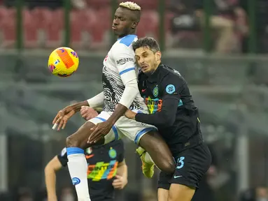 Penyerang Napoli Victor Osimhen (kiri) dan bek Inter Milan Andrea Ranocchia melompat saat berebut bola dalam lanjutan Liga Italia di Giuseppe Meazza, Senin (22/11/2021) dini hari WIB. Inter Milan sukses mengandaskan Napoli dengan skor tipis 3-2. (AP Photo/Antonio Calanni)